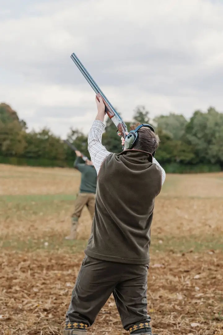 Person in shooting gear with ear protection wearing Forest Knightwood fleece gilet