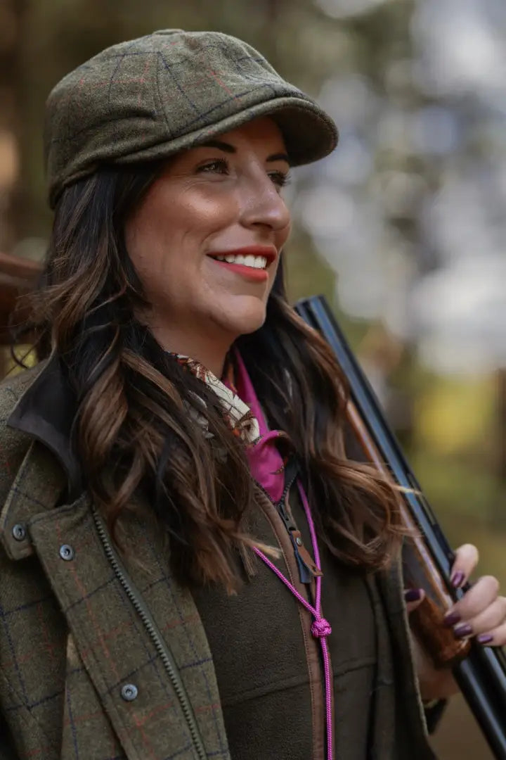 Smiling woman in a New Forest Ladies Baker Boy Hat with a tweed cap and jacket