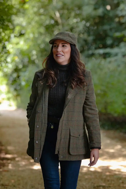Woman wearing a green tweed baker boy hat and stylish outfit outdoors