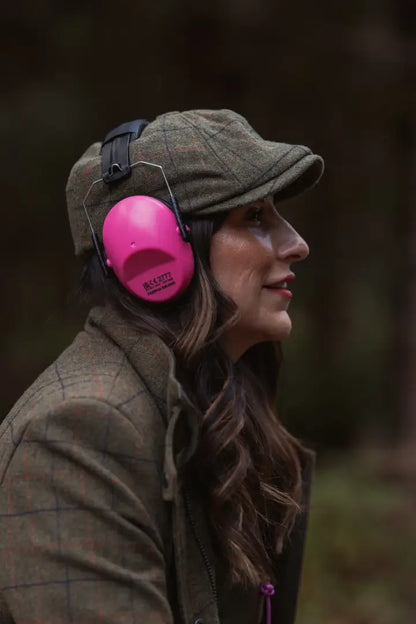 Woman wearing a New Forest Ladies Baker Boy Hat with pink ear defenders and tweed cap
