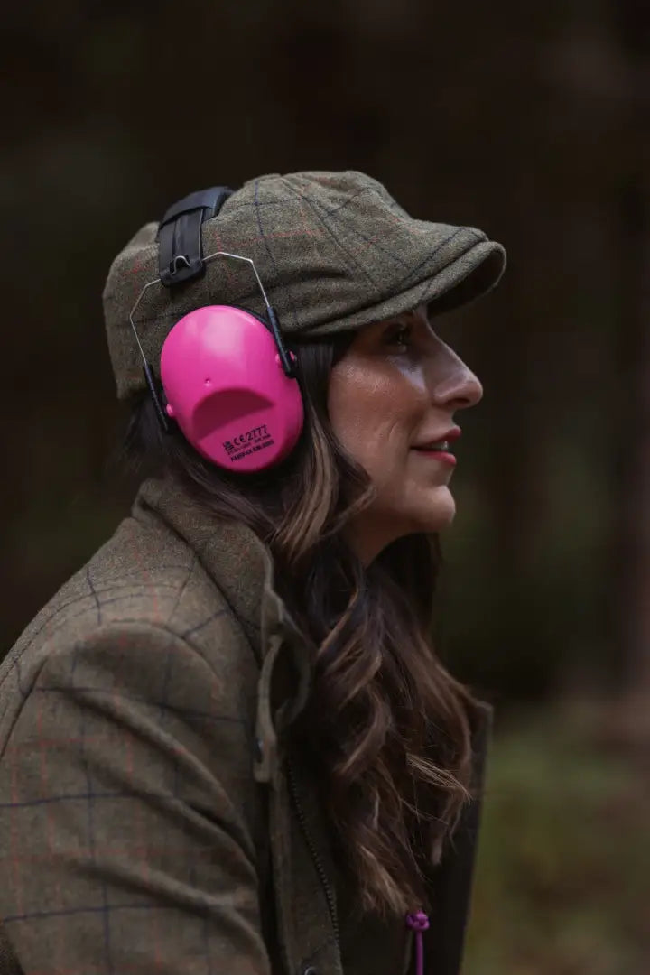 Woman wearing a New Forest Ladies Baker Boy Hat with pink ear defenders and tweed cap