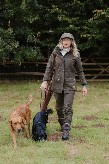 Woman in a ladies country sport jacket with dogs in the forest