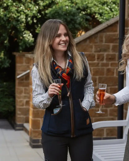 Woman in forest ladies fleece gilet with plaid shirt and rosé drink casual style