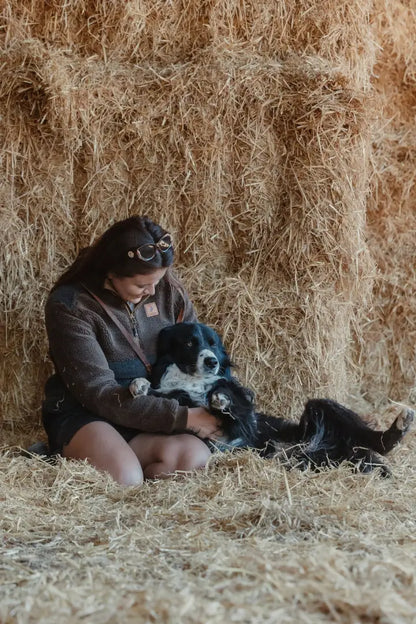 Woman cuddling dog on New Forest Ladies Fox Fibre Pile Fleece in hay field relaxing