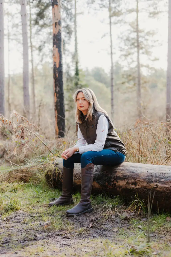 Woman in riding boots and vest wearing a stylish New Forest heated gilet