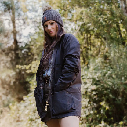 Woman wearing a stylish New Forest ladies knitted hat and dark winter coat outdoors