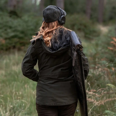 Woman with shotgun and ear protection wearing Forest Ladies Marsh Jacket in the forest