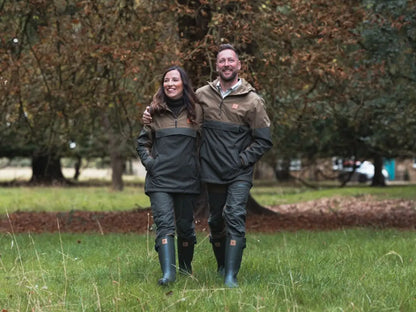 Two people in matching forest nightjar smocks and rubber boots outdoors