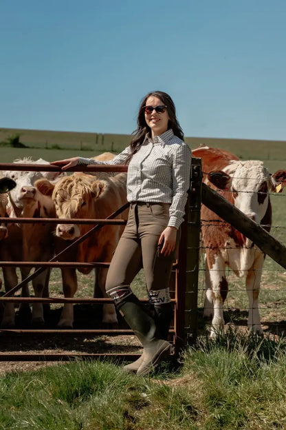 Woman in riding attire with cows.