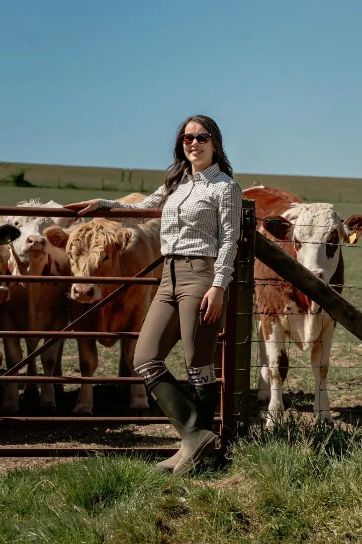 Woman in riding attire with cows.