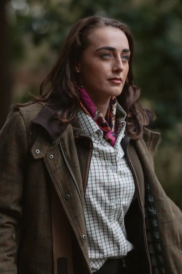 Woman wearing a brown tweed jacket over a plaid shirt and silk scarf, favorite country shirt