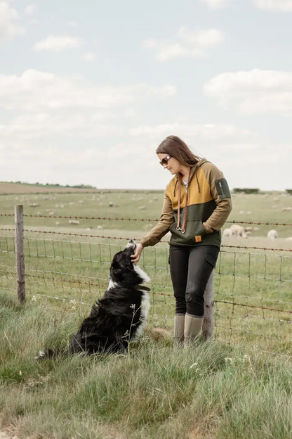Woman petting border collie in New Forest Ladies Raptor Hoodie, perfect forest raptor style