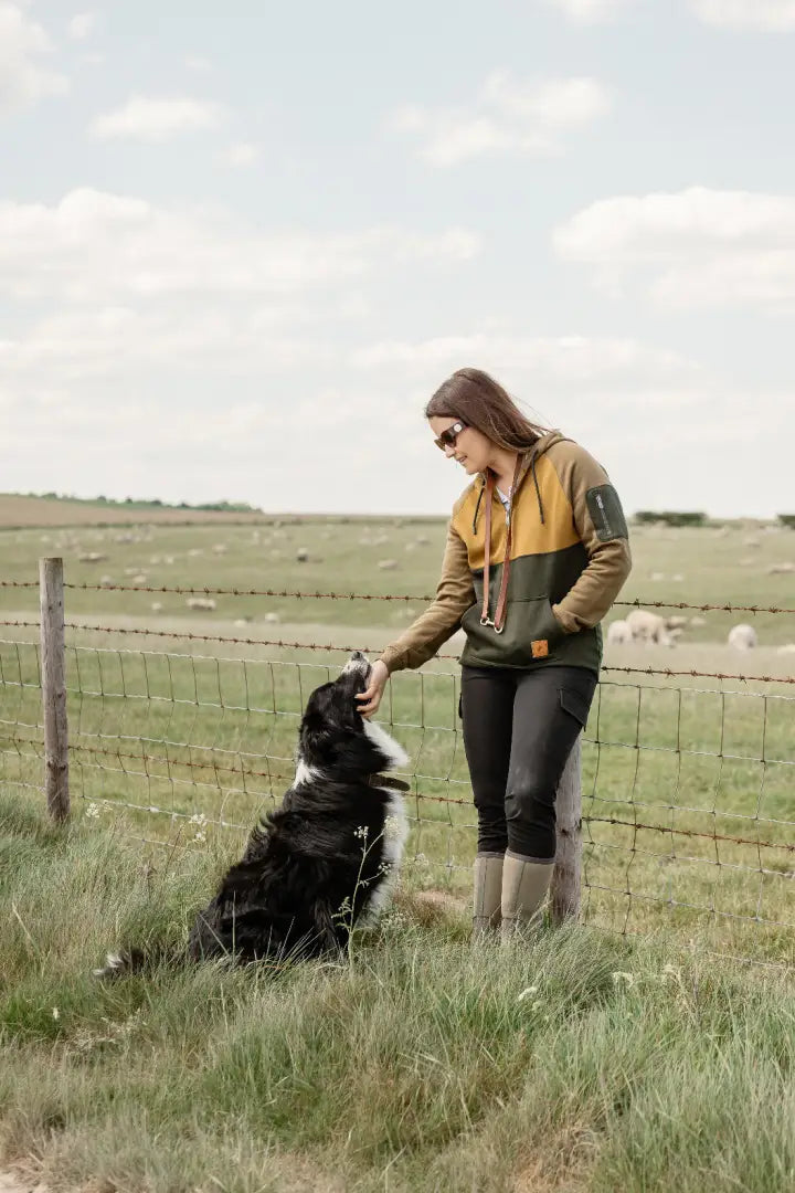 Woman petting border collie in New Forest Ladies Raptor Hoodie, perfect forest raptor style