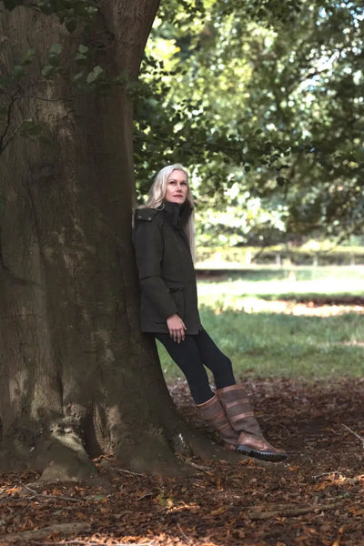 Woman in dark green Forest Ladies Robyn Jacket with black pants and striped boots