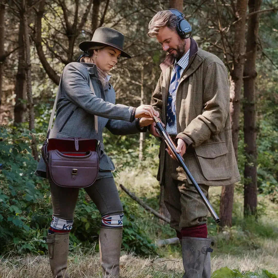 Two people loading a shotgun in New Forest Maverick Waterproof Tweed Breeks