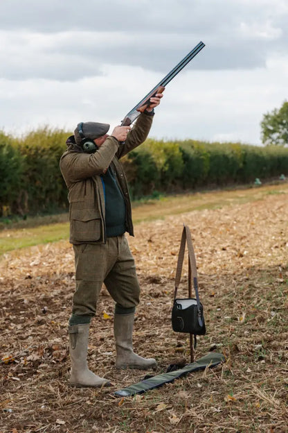 Man in hunting attire aiming with forest maverick waterproof tweed breeks