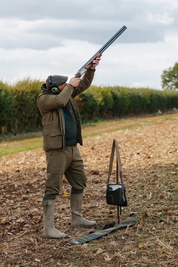 Man in hunting attire aiming with forest maverick waterproof tweed breeks