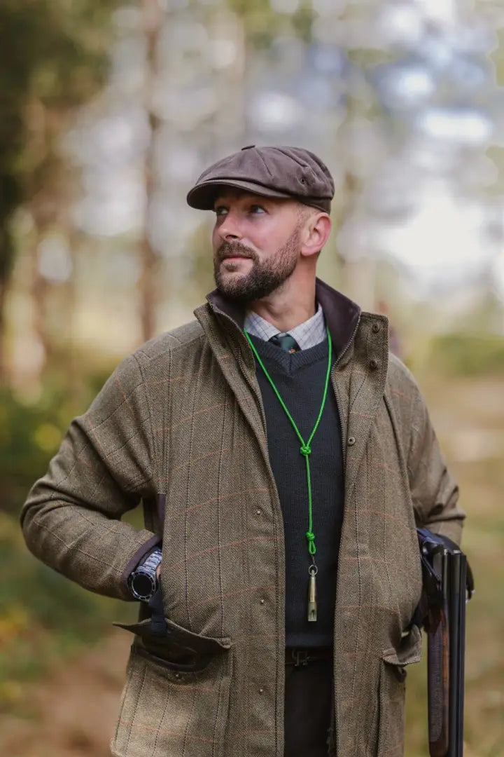 Man in a New Forest Maverick Waterproof Tweed Jacket with flat cap and shotgun outdoor look