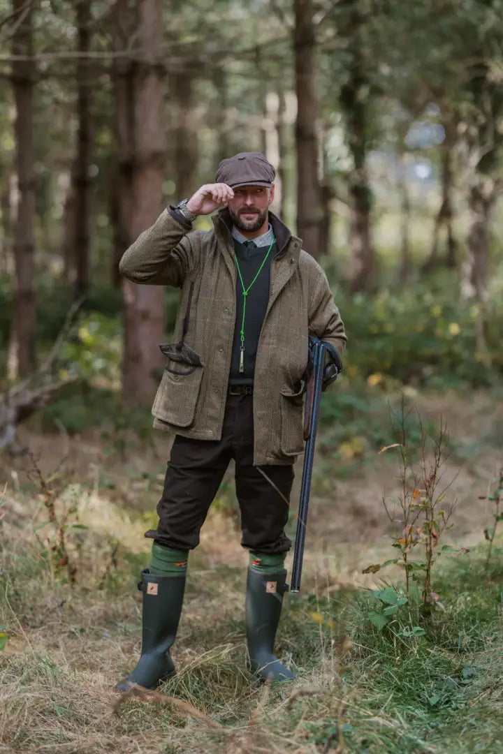 Man in hunting attire with shotgun wearing New Forest Maverick Waterproof Tweed Jacket