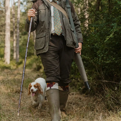 Hunter in New Forest Moleskin Breeks walking with a spaniel dog in the woods