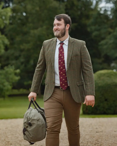 Man in green tweed jacket with duffel bag wearing New Forest Moleskin Jeans