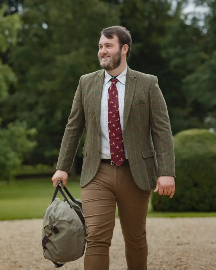 Man in green tweed jacket with duffel bag wearing New Forest Moleskin Jeans