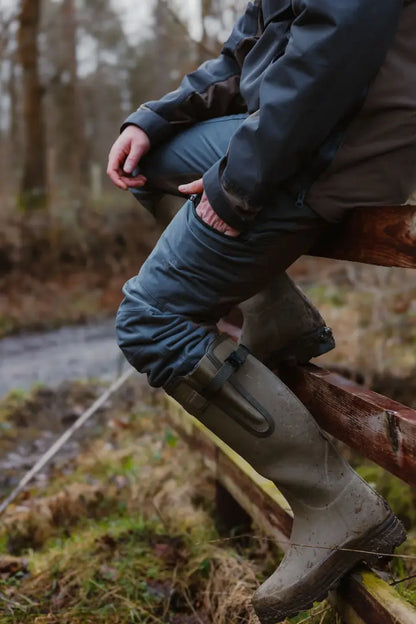 Muddy green rubber boots paired with New Forest Nightjar Trousers for outdoor adventures