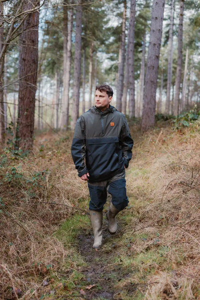 Man in outdoor gear walking through woods wearing Forest Nightjar Trousers