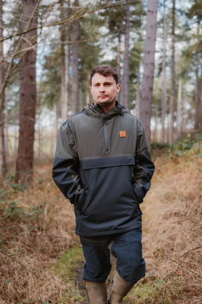 Man in a two-tone hooded anorak with Forest Nightjar Trousers stylishly paired