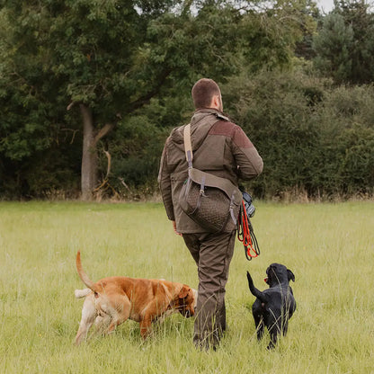 Hunter in New Forest Performance Field Coat walking two dogs in a field