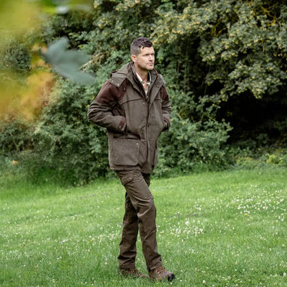 Man in brown outdoor jacket and pants, showcasing New Forest Performance Field Coat