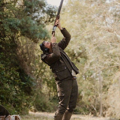 Person in hunting attire holding a shotgun with New Forest Performance Field Coat