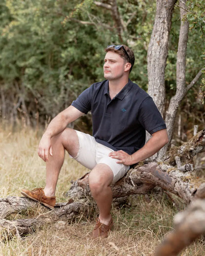 Man in a New Forest Pique Polo Shirt wearing shorts, perfect for casual style