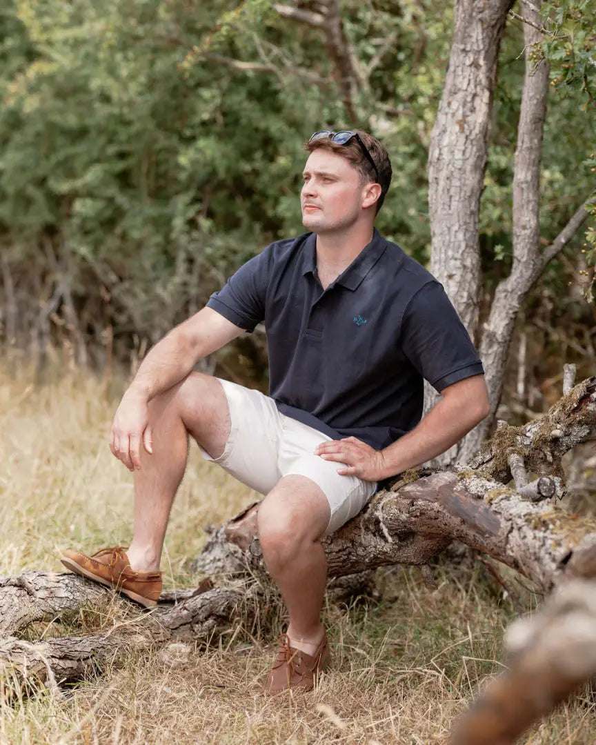 Man in a New Forest Pique Polo Shirt wearing shorts, perfect for casual style