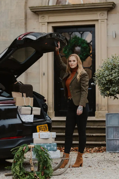 Woman unloading Christmas gifts from car wearing a stylish Polly Tweed Blazer