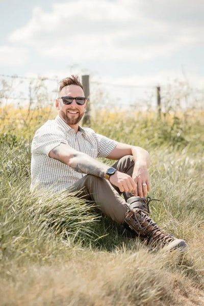 Man in sunglasses wearing New Forest Premium 100 Cotton Short Sleeve Shirt sitting in grass