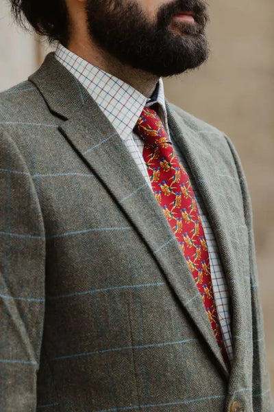 Man in a stylish wool tweed blazer with a red tie, perfect for Forest clothing