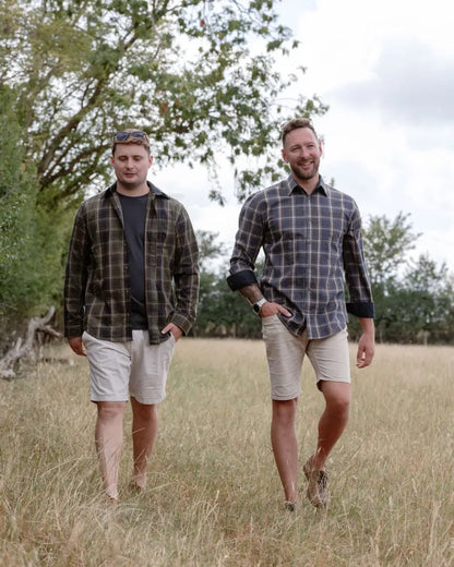 Two men walking in a field wearing forest premium tattersall shirts for casual style