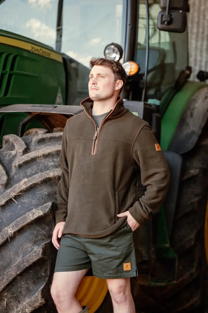 Man in outdoor country clothing posing by tractor wearing New Forest Rugby Shorts for hunting