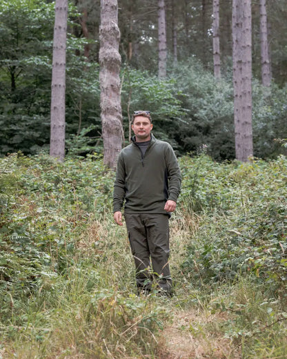 Man in olive green New Forest Trail Fleece outdoors in forest trail gear