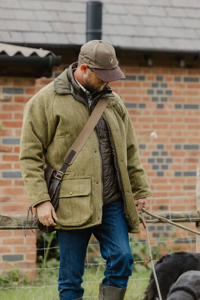 Man in a stylish tweed shooting jacket and cap, perfect for outdoor adventures