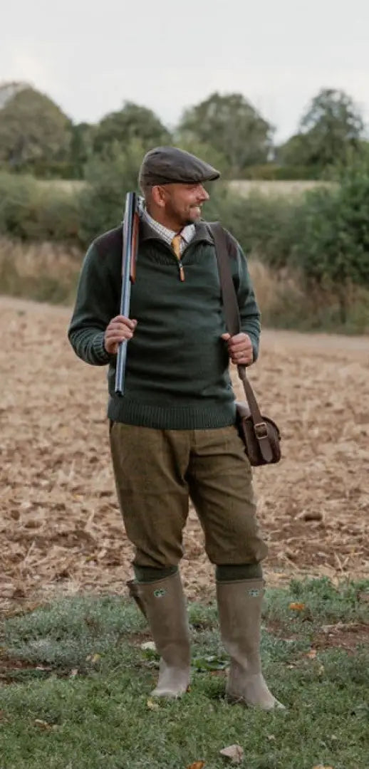 Man in forest woodlark waterproof jumper with hunting outfit, shotgun, and gear