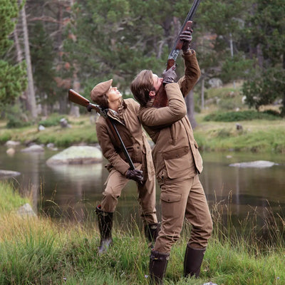 Two hunters aiming rifles in grass, showcasing ladies Percussion Rambouillet warm trousers