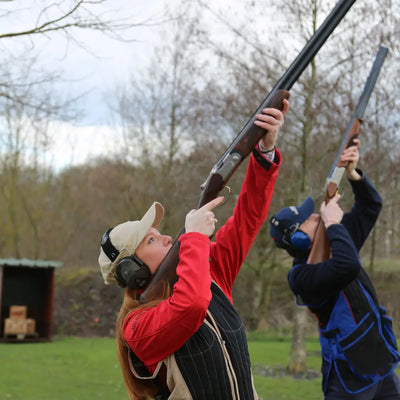 Two people in Percussion Skeet Vests aiming shotguns for clay pigeon shooting fun