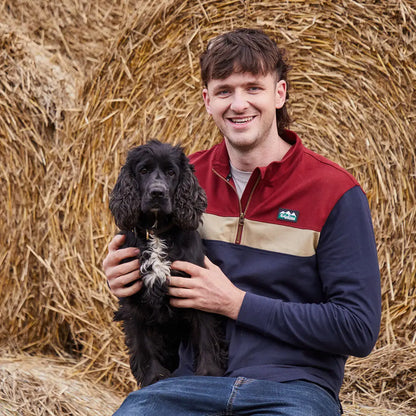 Man holding a black dog in Ridgeline Back Slider Rugby Top, perfect country clothing for hunting