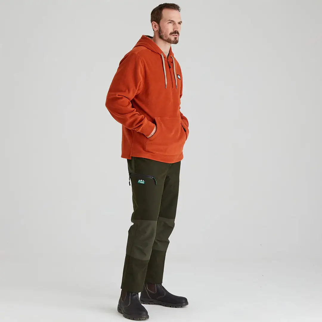Man wearing an orange hoodie and green pants in Ridgeline Ballistic Hooded Fleece, perfect for chilly autumn days