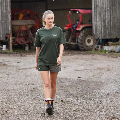 Young woman in green t-shirt and shorts on dirt path, perfect for country clothing and outdoors