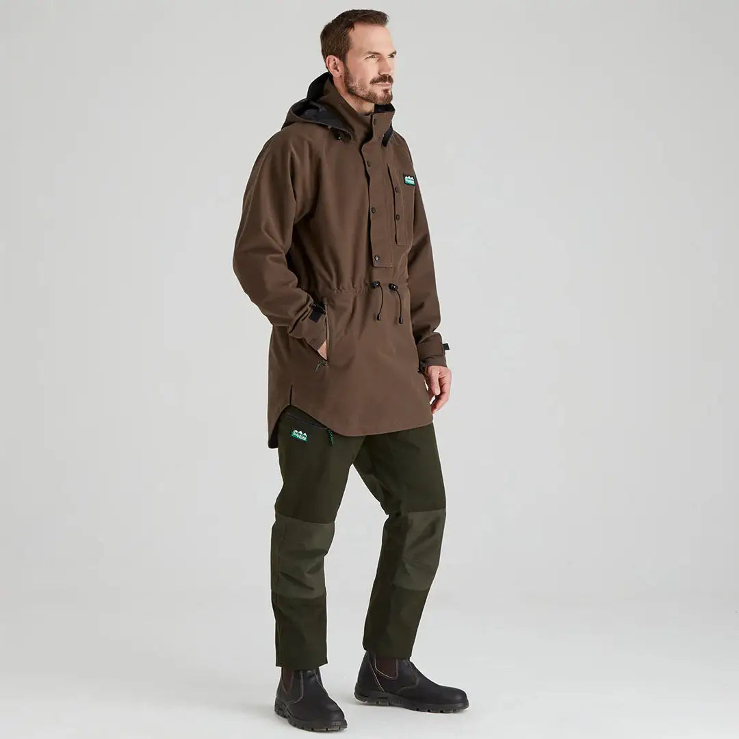 Man in brown hooded anorak and green pants wearing Ridgeline Mens Monsoon Classic Smock