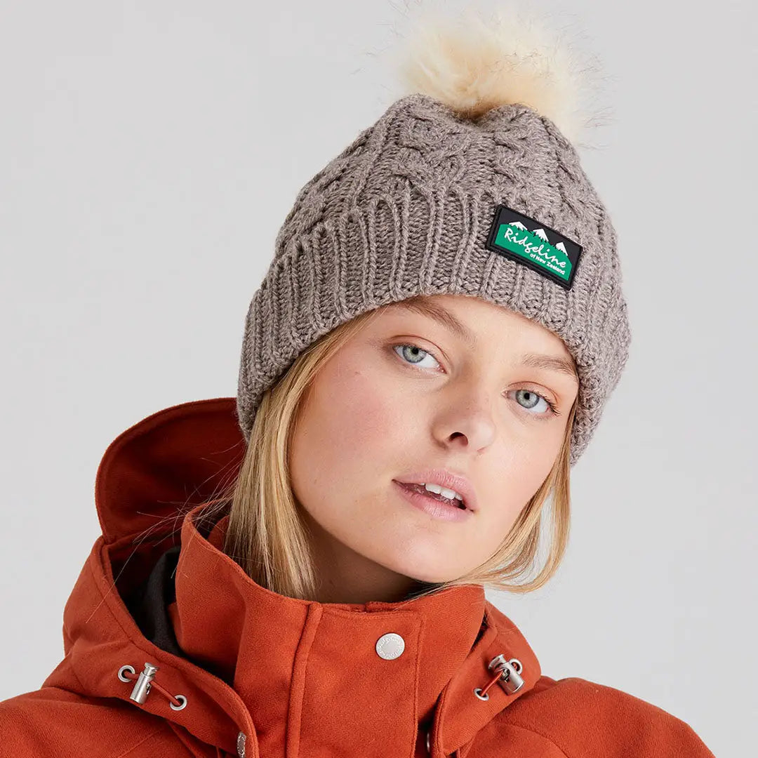 Grey cable-knit nordic fleck bobble hat with green white Ridgeline patch for style