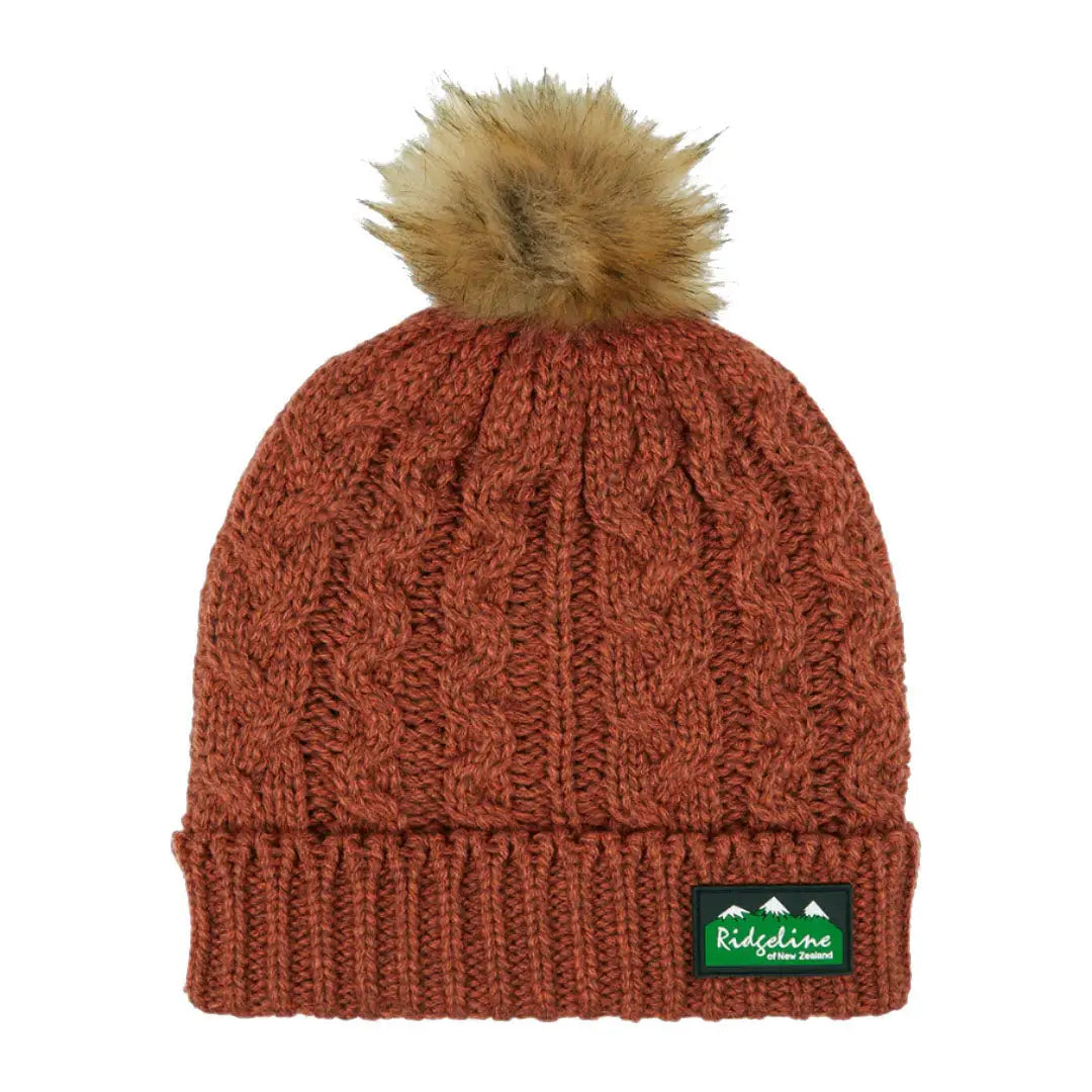 Rust-colored Nordic Fleck Bobble Hat with faux fur pom-pom for cozy winter style